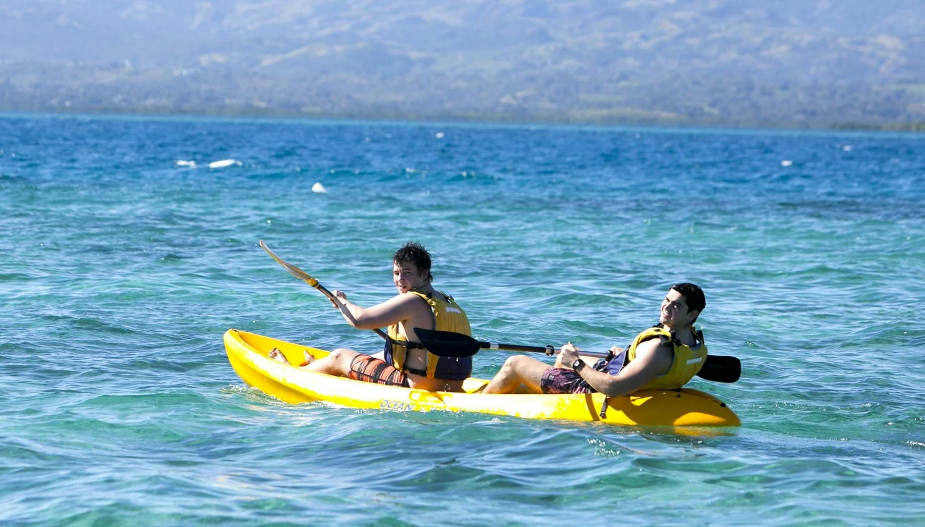 Two students kayaking on a gap year adventure in tropical waters.
