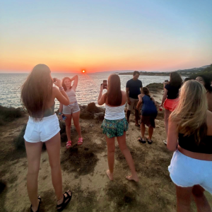 best service trips for teens girls taking photo of the red sunset and a fellow student