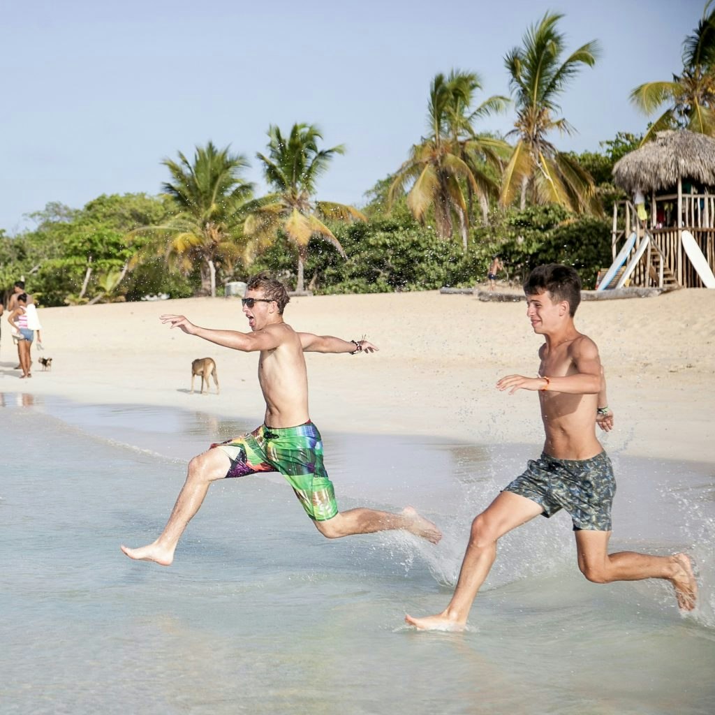 Teens on a best teen travel program in the Dominican Republic running in to the ocean.