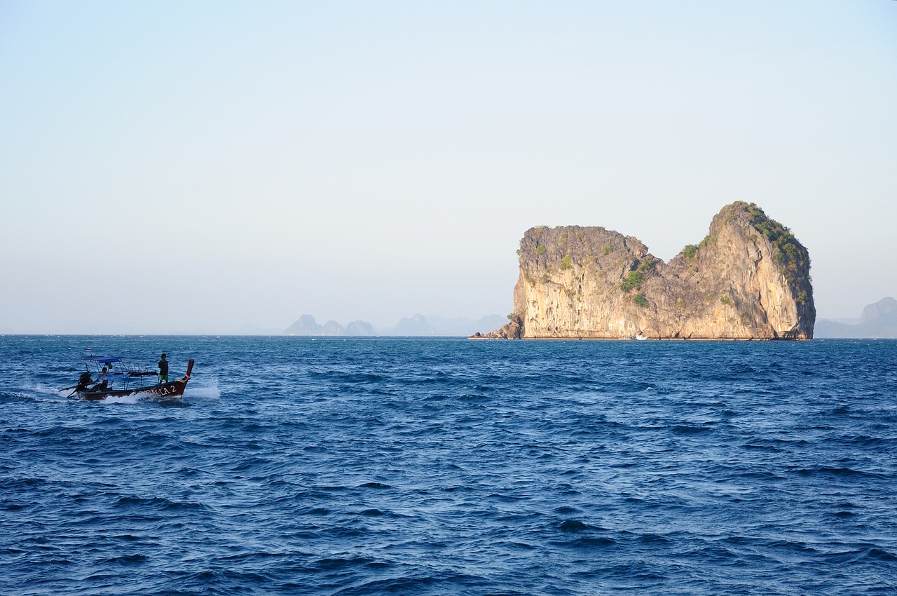A longtail boat carries students across the Andaman Sea near a limestone karst island