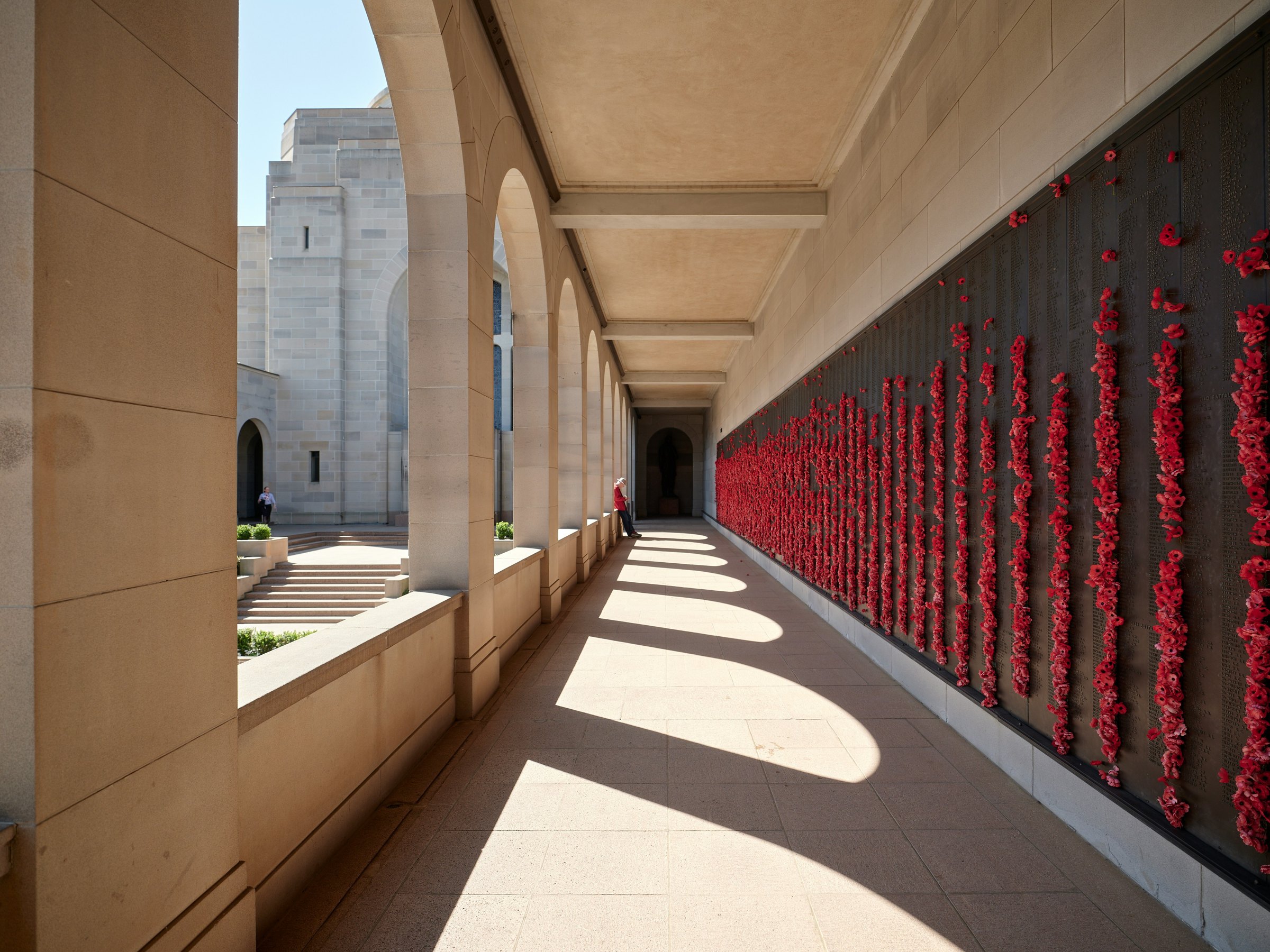 Red poppies pressed into the Roll of Honour along a colonnade at the war memorial