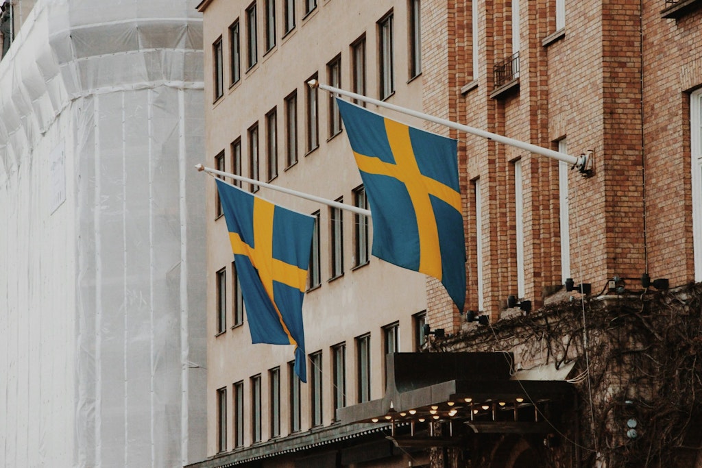 Buildings in Gamla Stan adorned with the Swedish flag in yellow and blue.