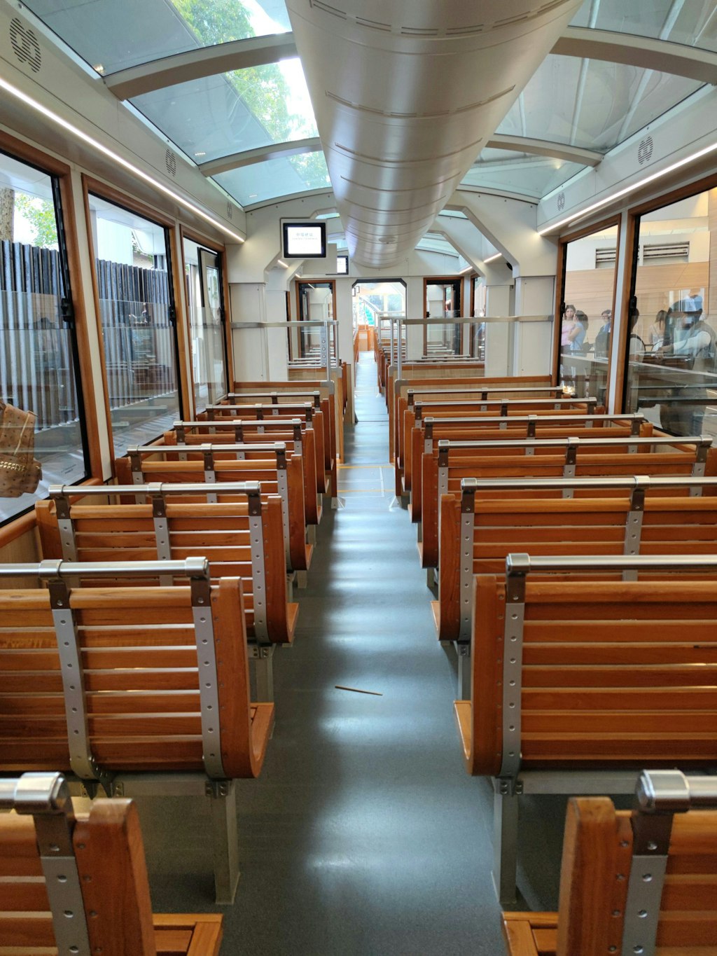 The sixth-generation tramcar features a dark green color from its 3rd and 4th generation predecessors. Train is empty. 