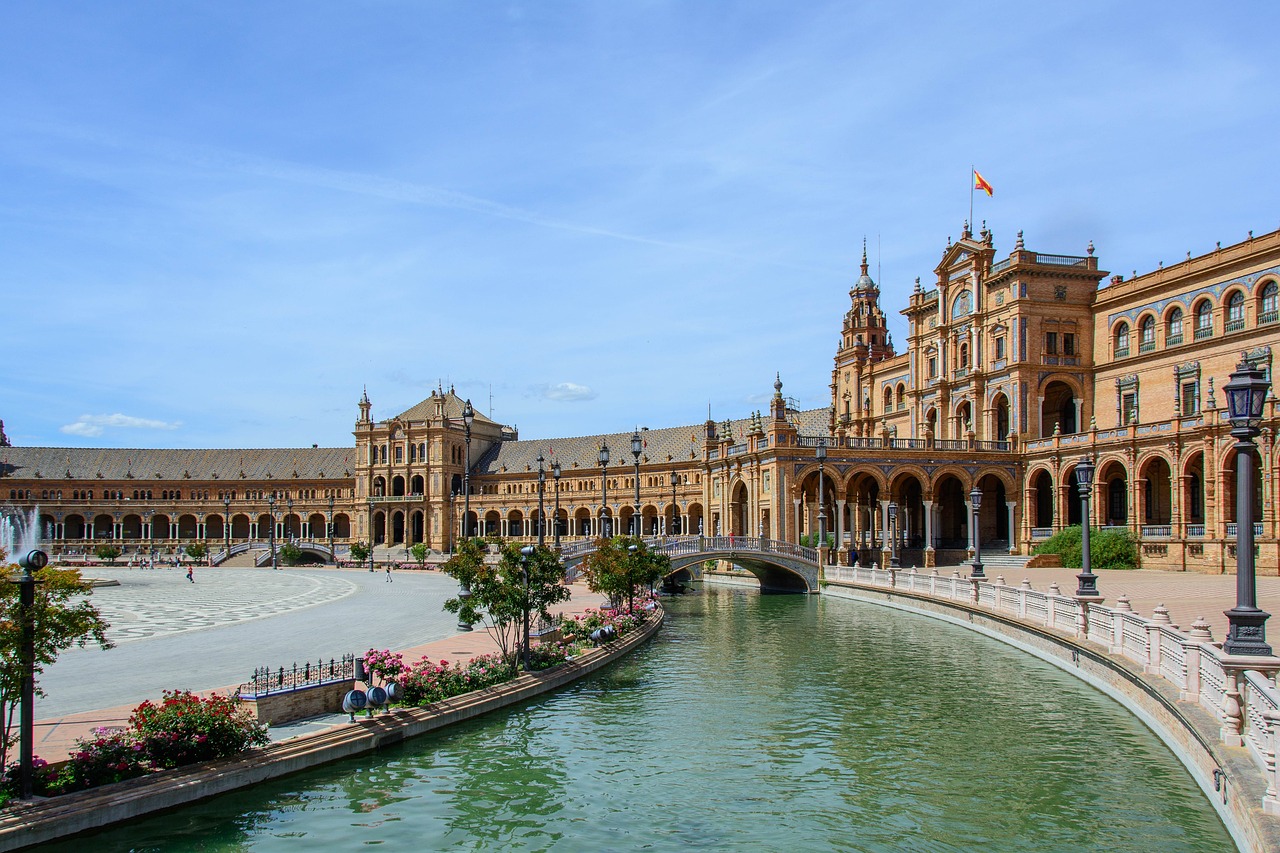 Plaza de España's canal and arched buildings under a blue sky in Seville