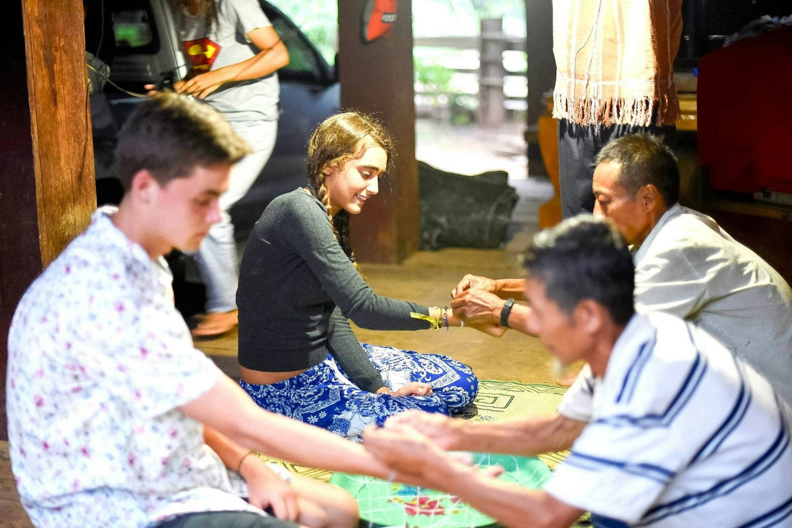 Gap year student participating in a cultural immersion activity with local community members.