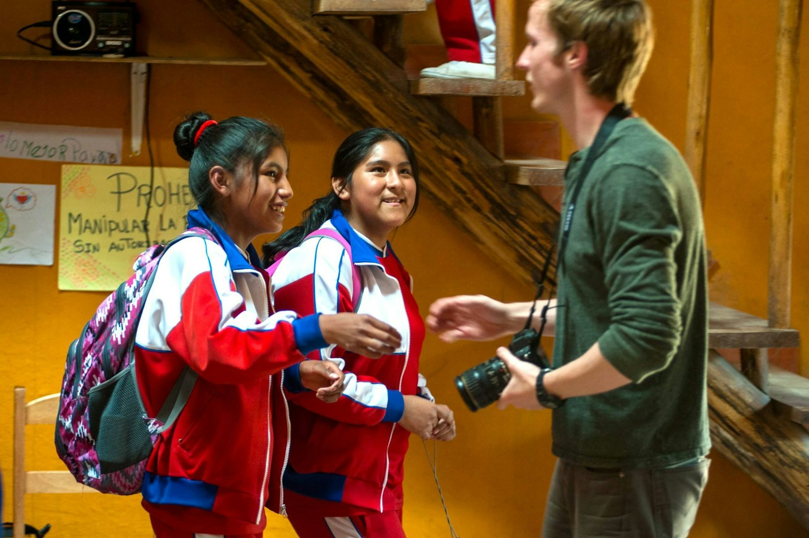 Gap year college deferral student volunteering in a school abroad, meeting local students.