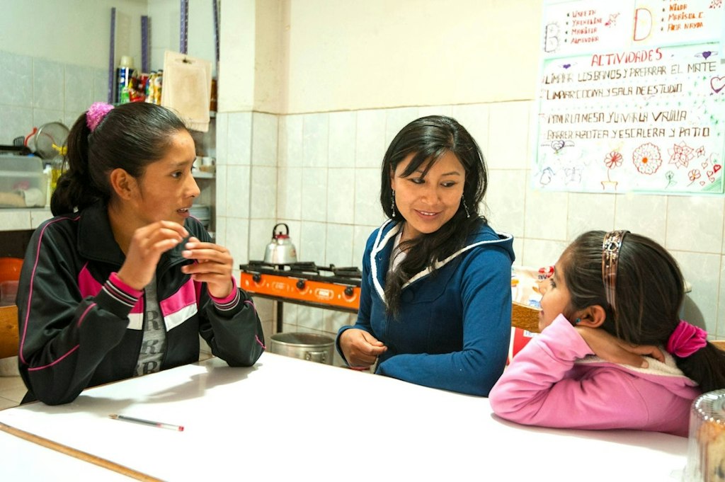 College volunteer abroad program student practicing Spanish and mentoring children during a cultural immersion experience.