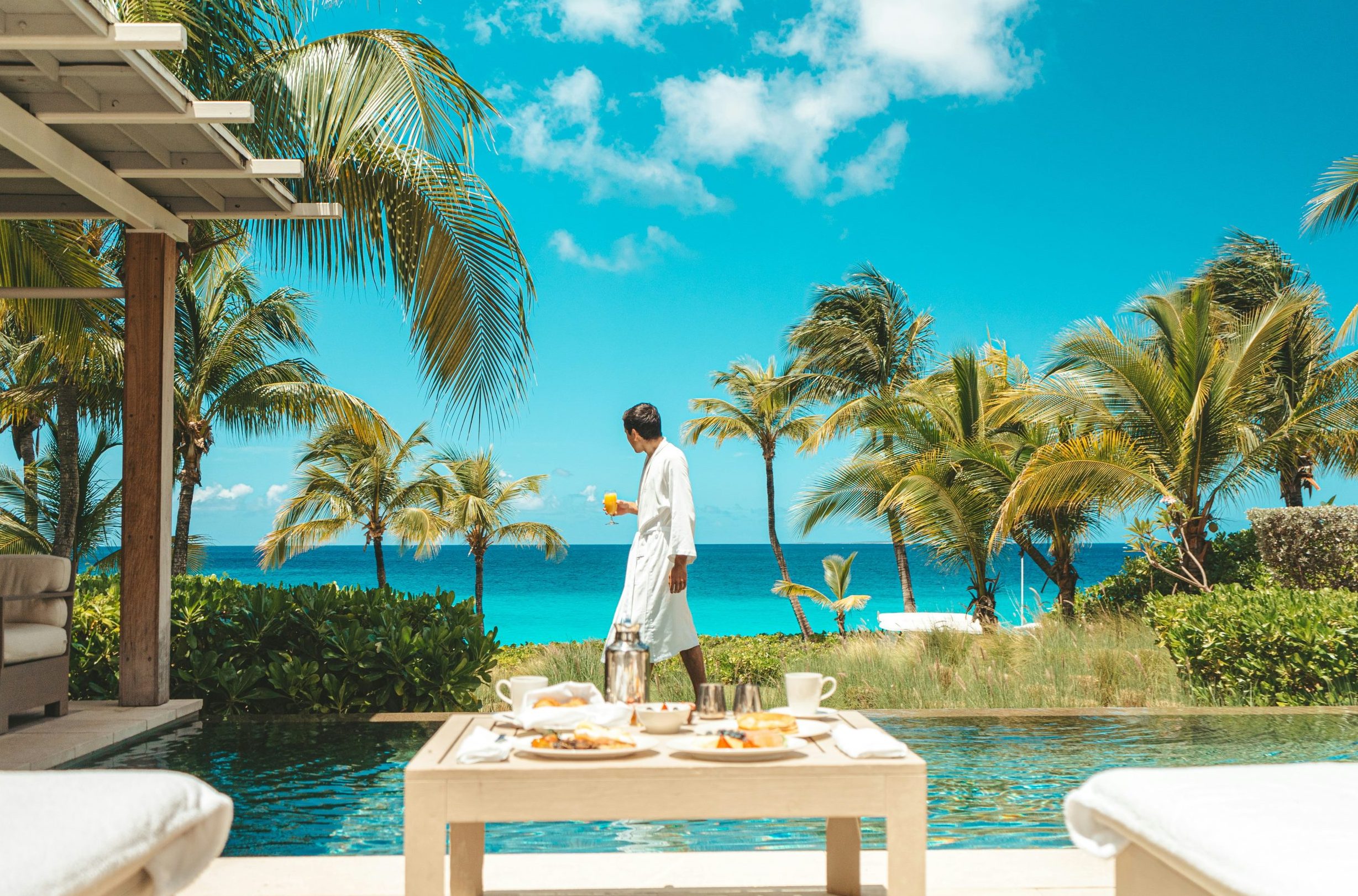 A man walks in front of the ocean.