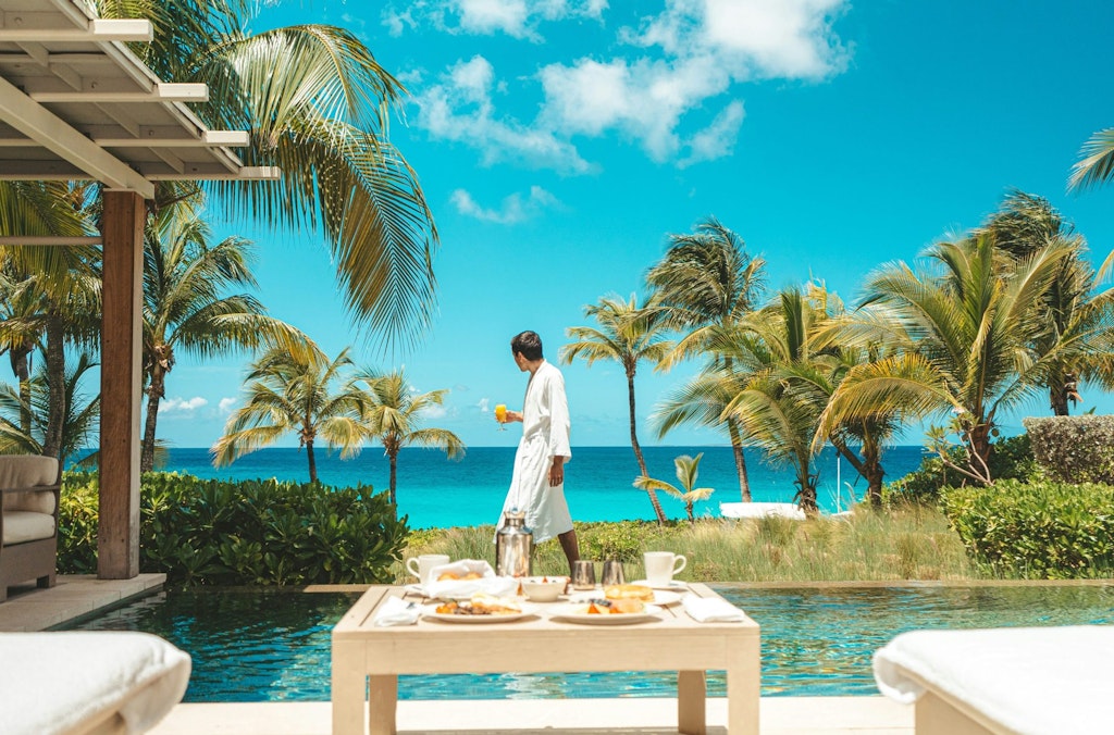 A man walks in front of the ocean.