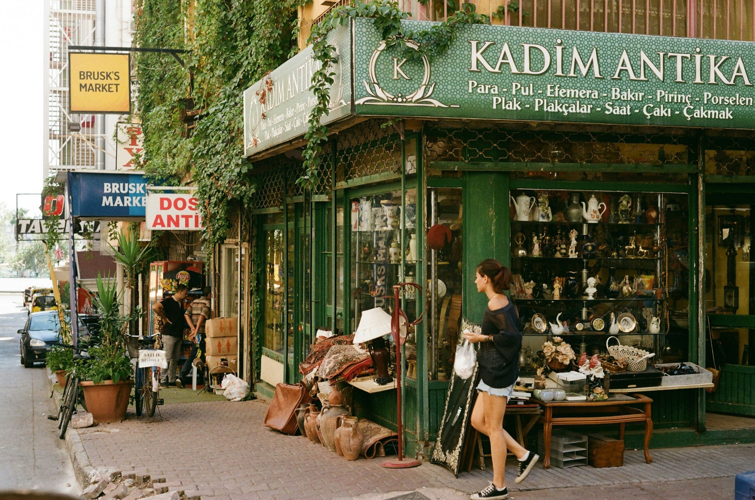 A young woman walks past a green shop in Antalya, Turkey.