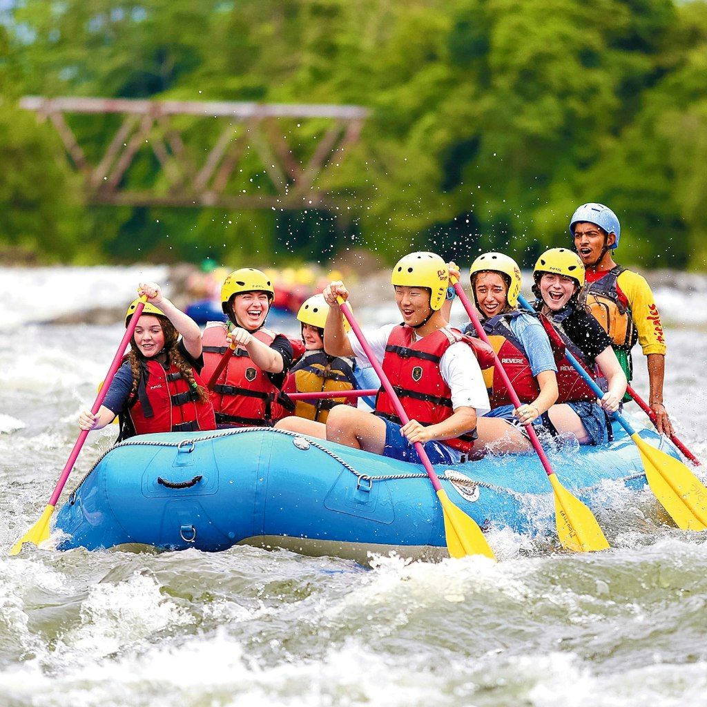 group of rustic pathways students rafting in the water on one of rustic pathways many cas trips