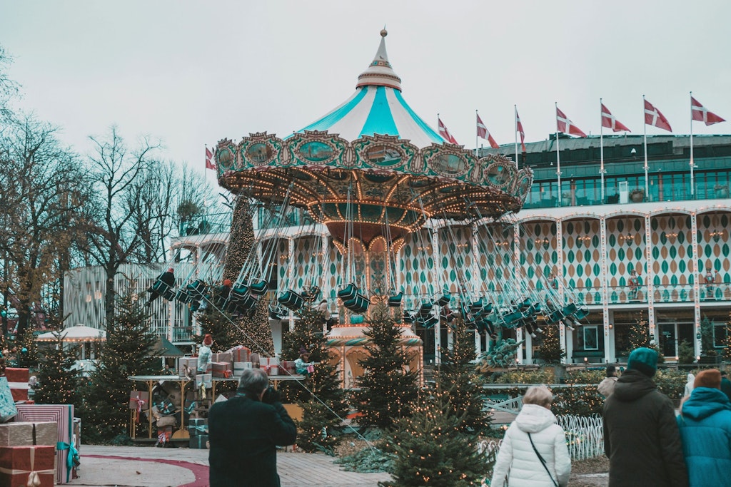 Tivoli Park's chain carousel with people and Danish flags in the back.