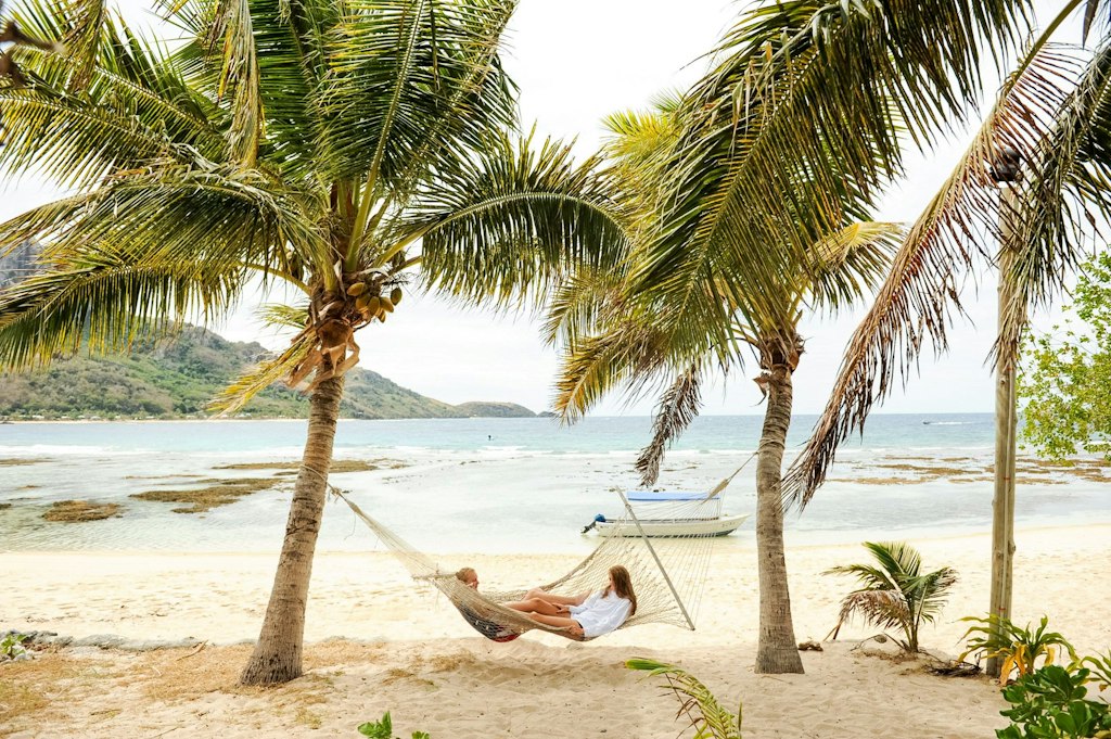 Student relaxing in a hammock on a beach in Fiji after a Rustic Pathways volunteer abroad project, representing safe, balanced travel and well-being during service programs.