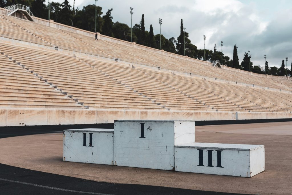 Empty podium with I, II, and III for medal winners in a stadium.