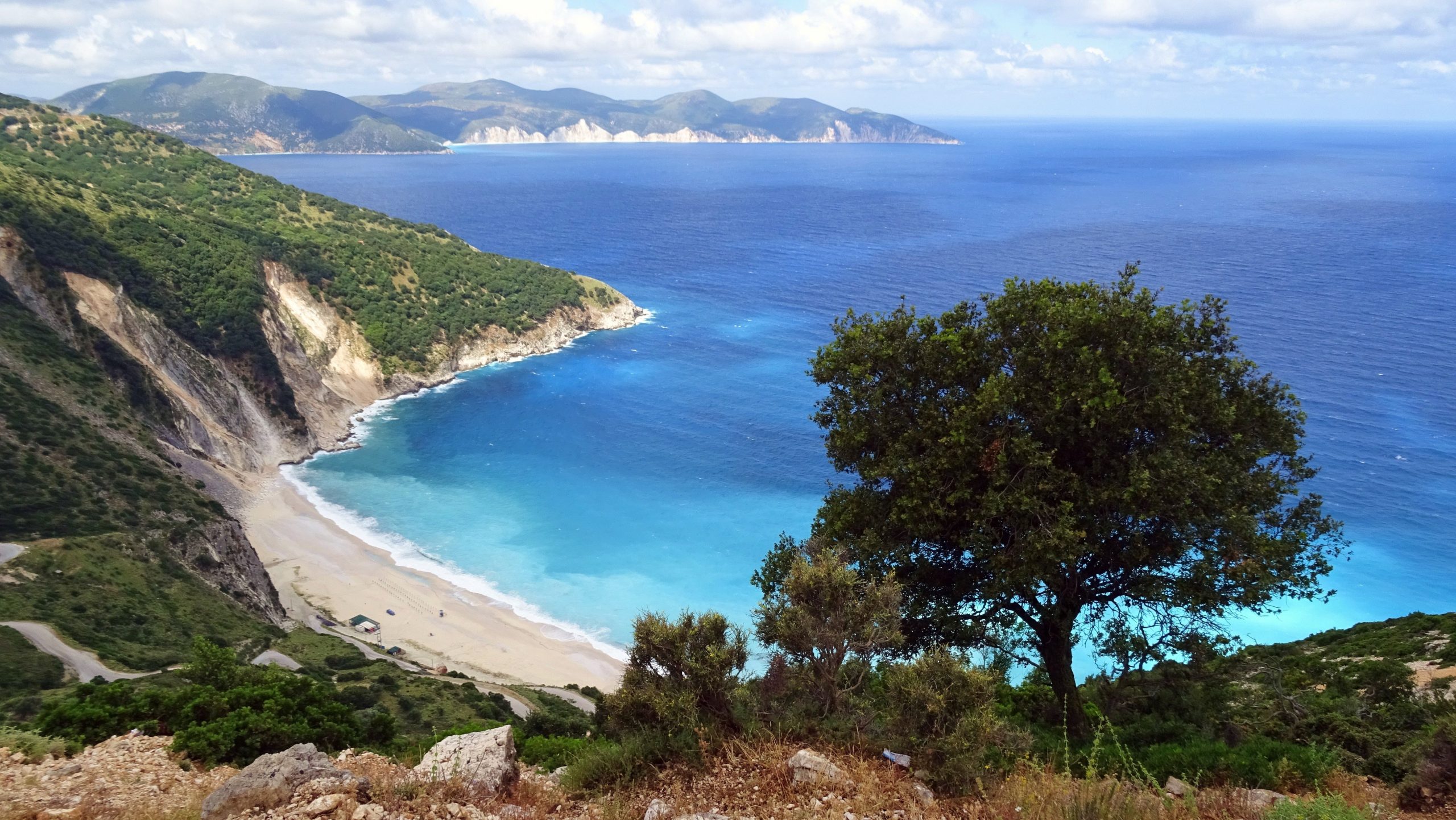 Aerial view of beach in Greece with ocean in the background.