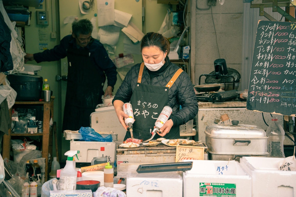 A woman works at a stall in Tsukiji Fish Market.