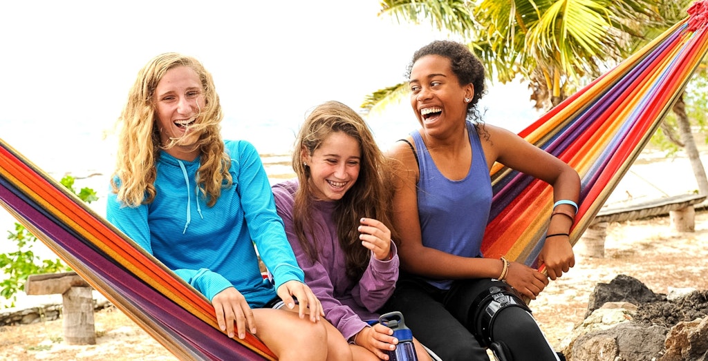 How to plan a teen travel teens sitting and laughing at the beach