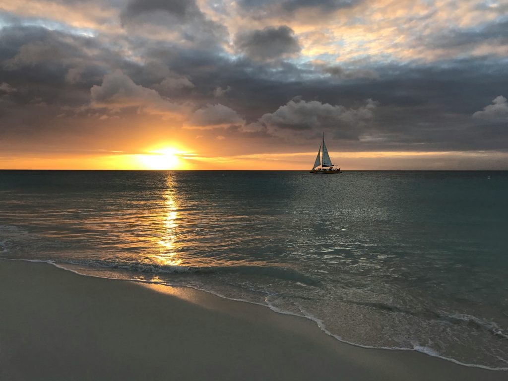 Aruba eagle bach, sunset and sail boat on the ocean
