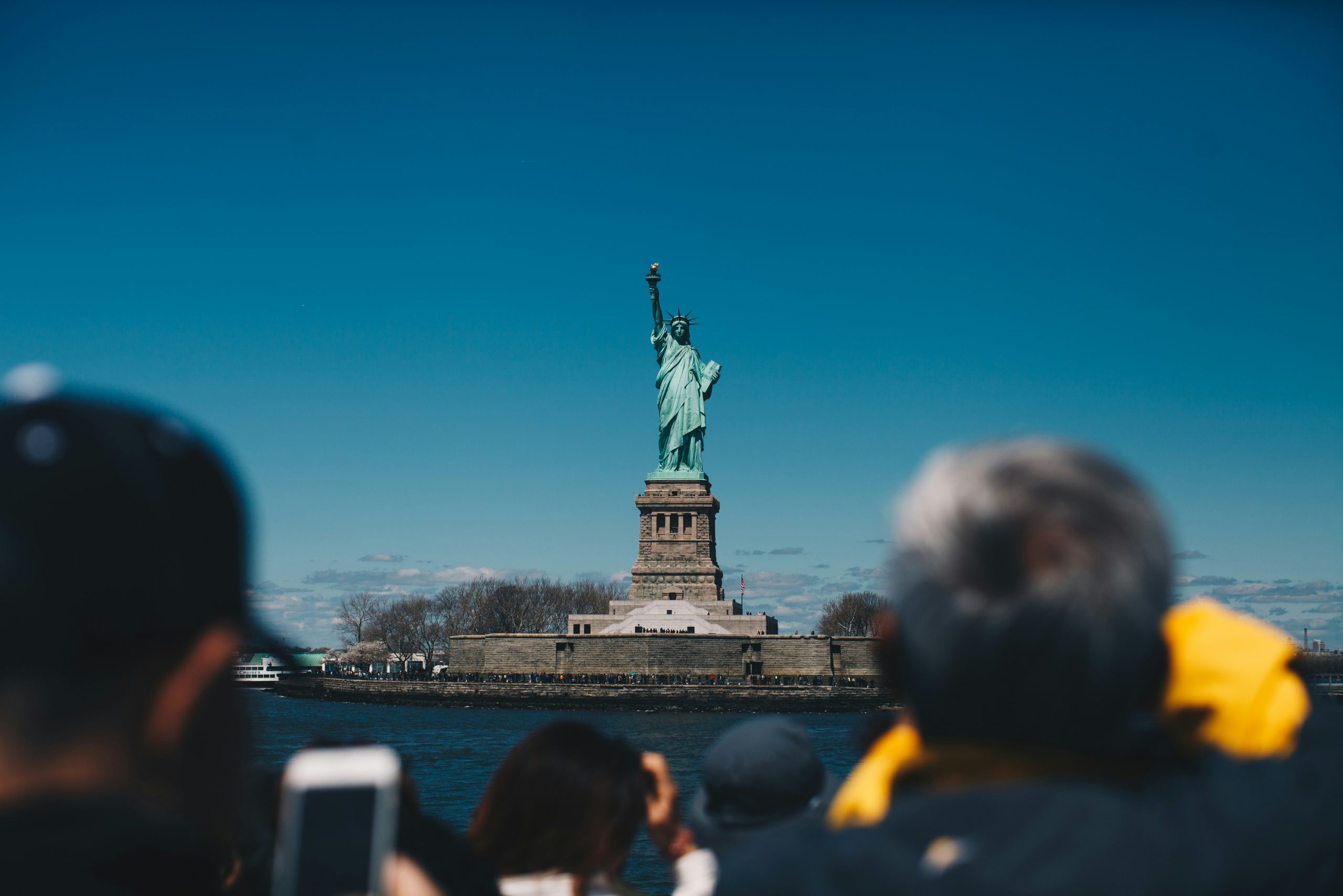 Tourists take photos of the Statue of Liberty.