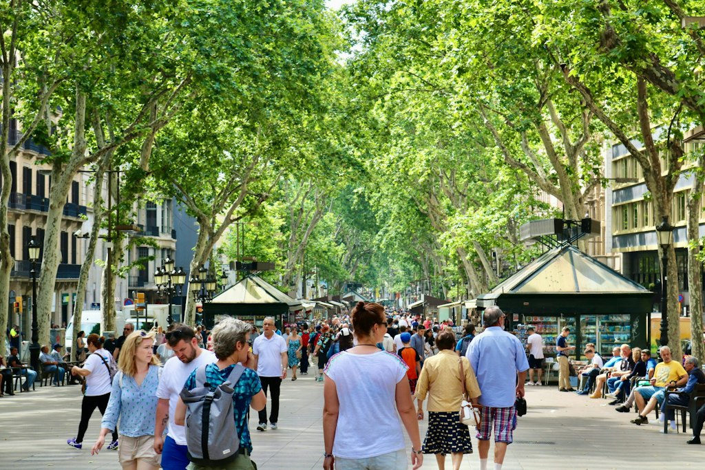 Pedestrians walk down La Rambla in Barcelona. Learn more fun facts about Barcelona.