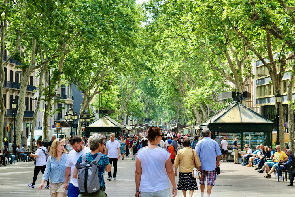 Pedestrians walk down La Rambla in Barcelona. Learn more fun facts about Barcelona.