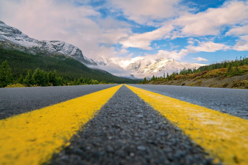 A close-up shot of the trans-canadian highway with mountains in the background.