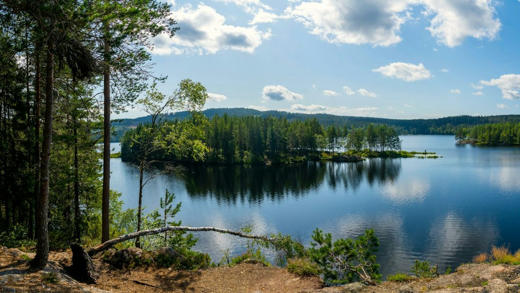 Blue skies are reflected in the waters of a lake in Oslo. Learn fun facts about Oslo.