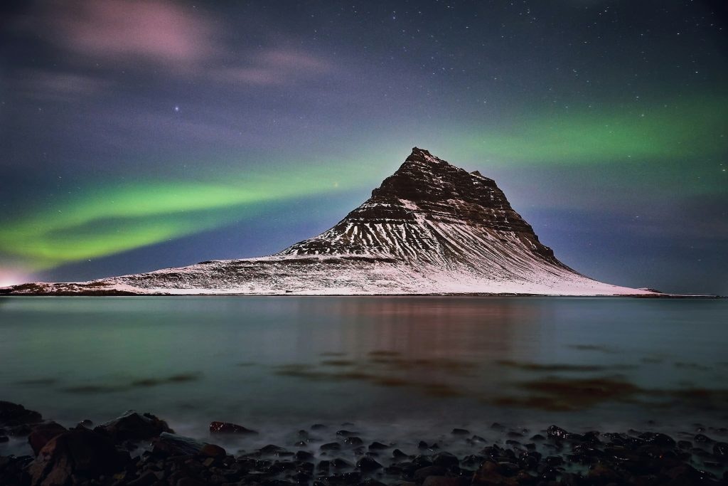Kirkjufell mountain in Iceland, illuminated by the Northern Lights.