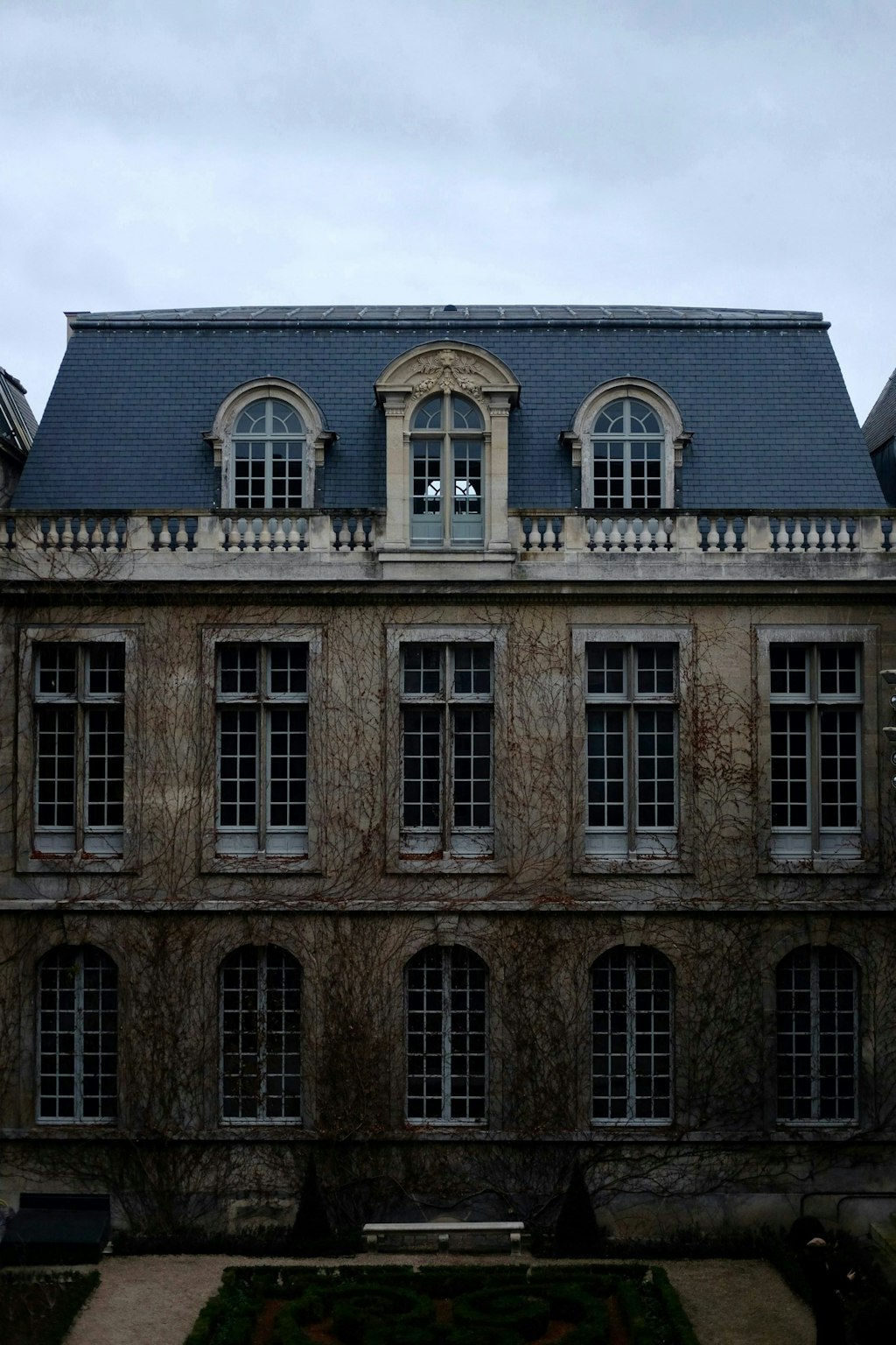 The fa&ccedil;ade of the Mus&eacute;e Carnavalet in Paris showcases a blend of Renaissance and classical architecture. Its pale stone exterior features intricate carvings, tall windows, and grand double doors framed by columns. 