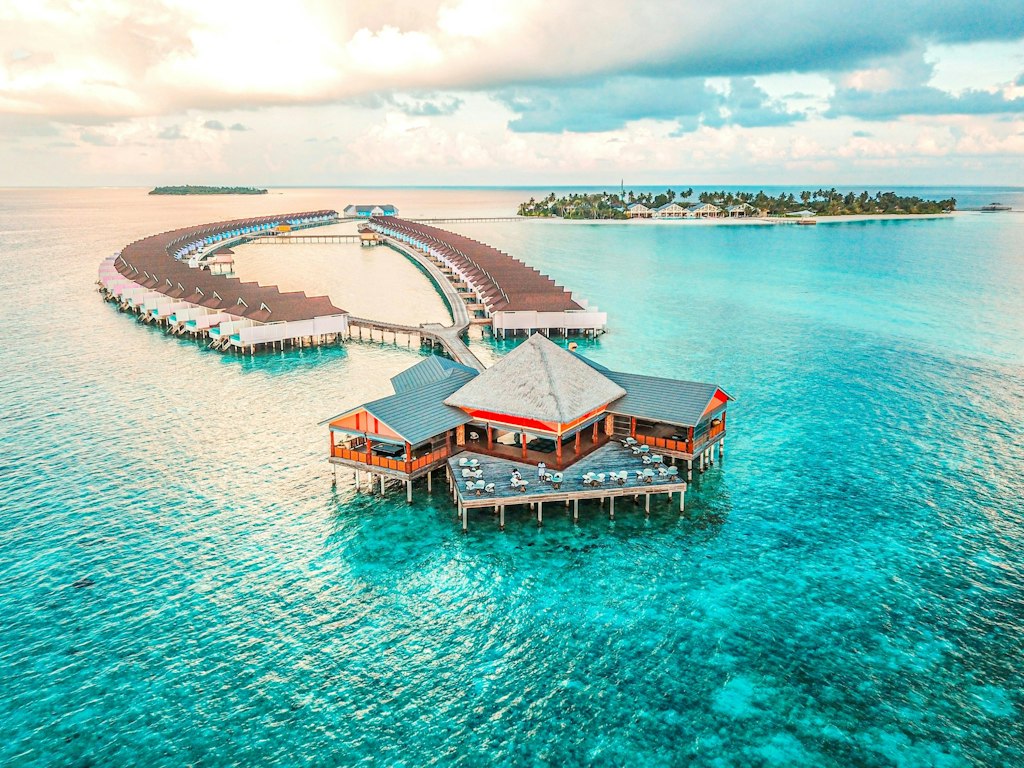 A stunning view of Maldives' iconic overwater bungalows surrounded by turquoise waters — a picture-perfect example of luxury travel and fun facts about the Maldives and its resorts.