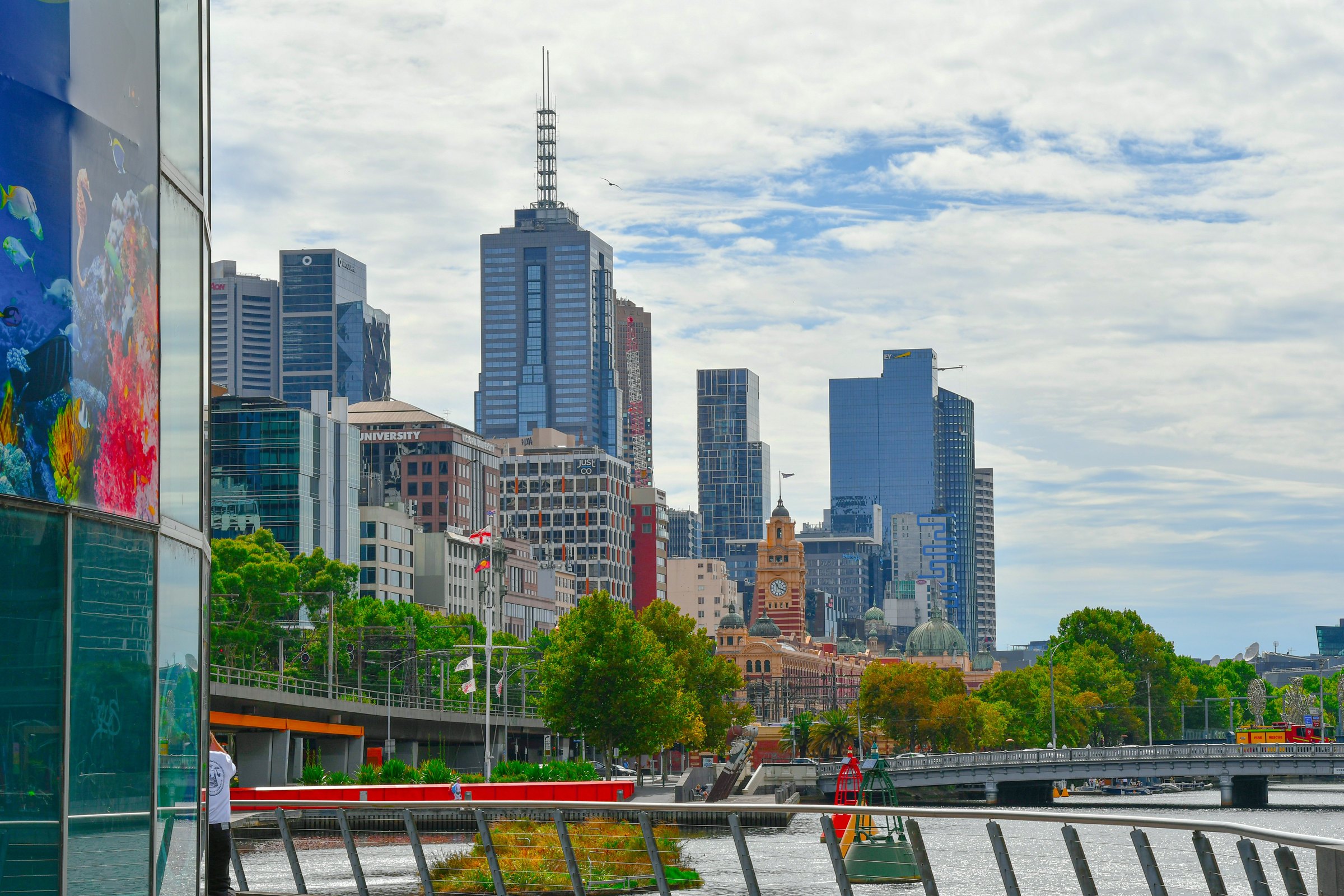 Melbourne city towers rise behind the Yarra River and the Southbank promenade