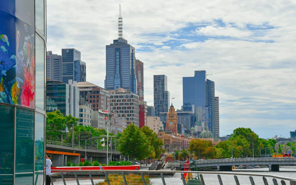 Melbourne city towers rise behind the Yarra River and the Southbank promenade