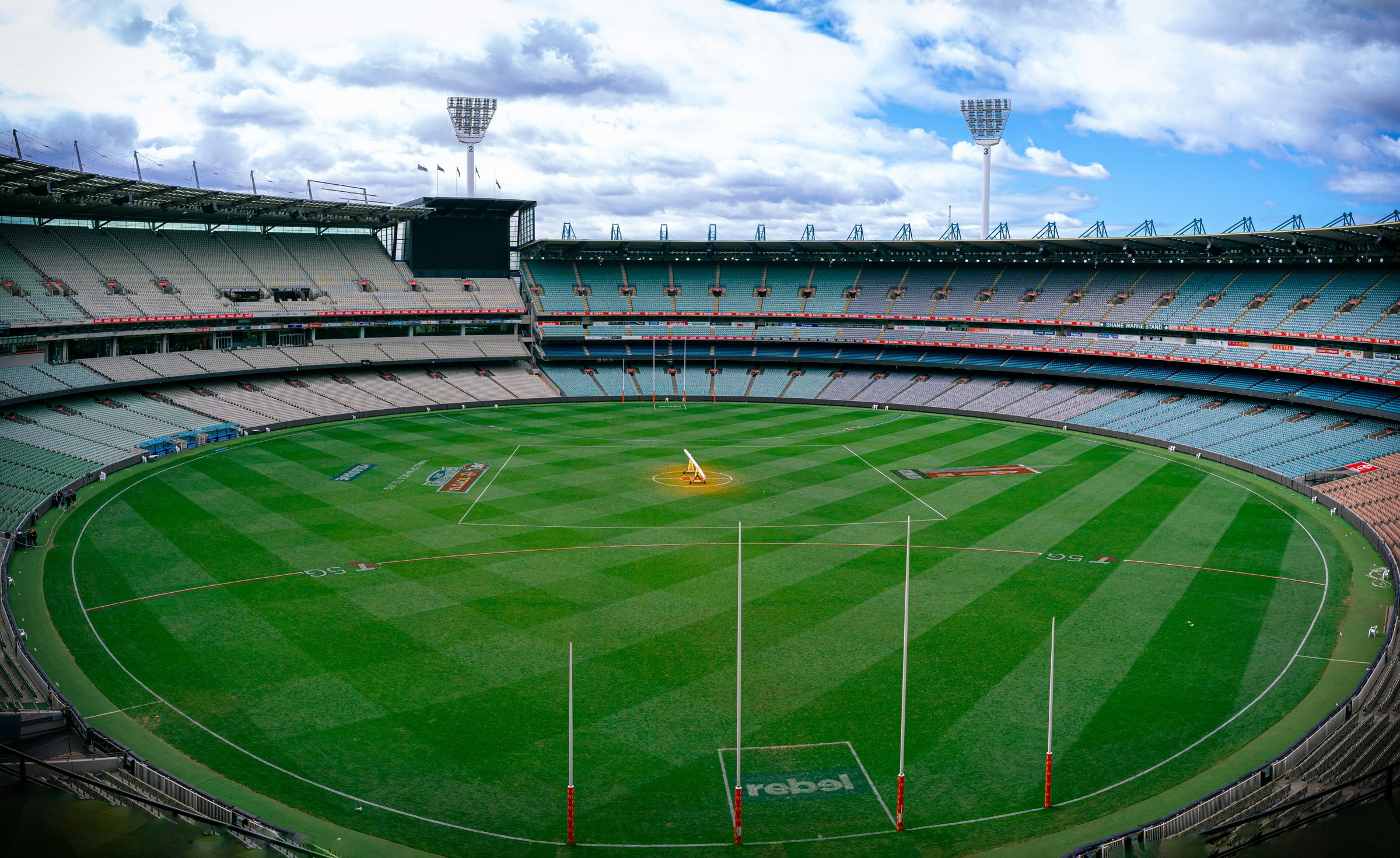 The empty oval and tiered stands of the Melbourne Cricket Ground under cloud