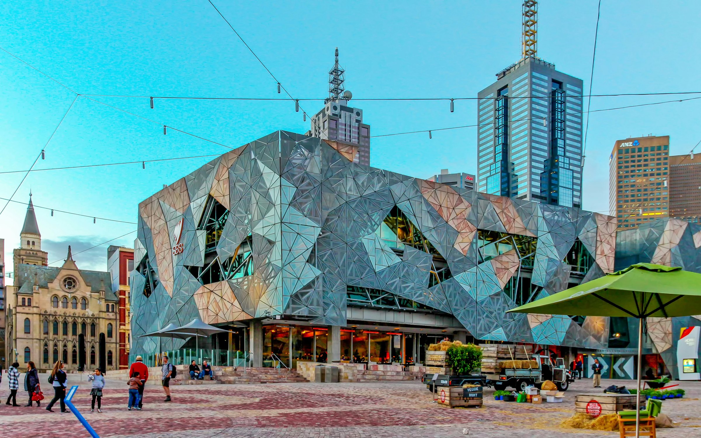 The angular facade of Federation Square in Melbourne with city towers behind