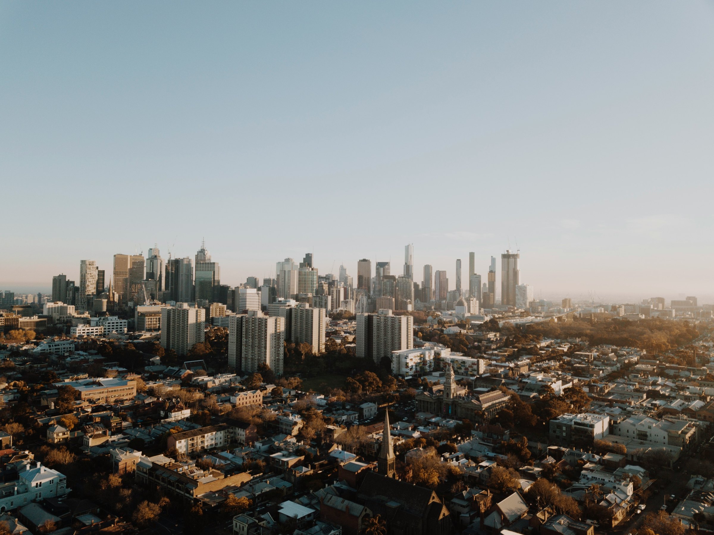 Melbourne city towers on the horizon beyond the rooftops of the inner suburbs