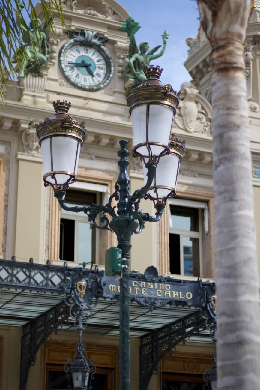 A quiet street lit in the evening beside a classical stone building.
