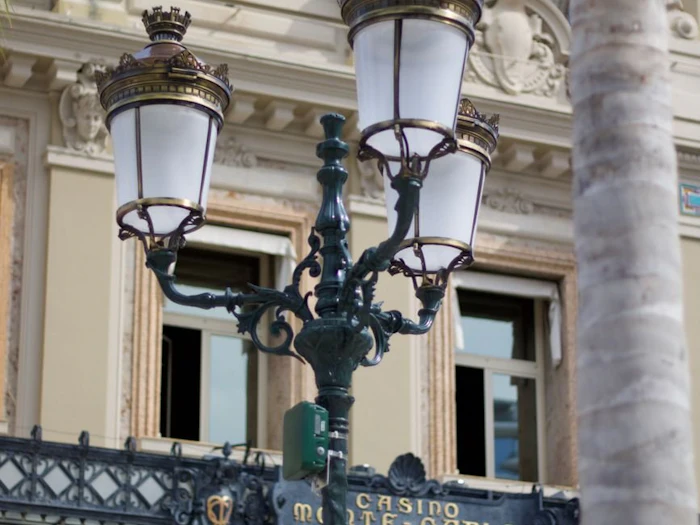 A quiet street lit in the evening beside a classical stone building.