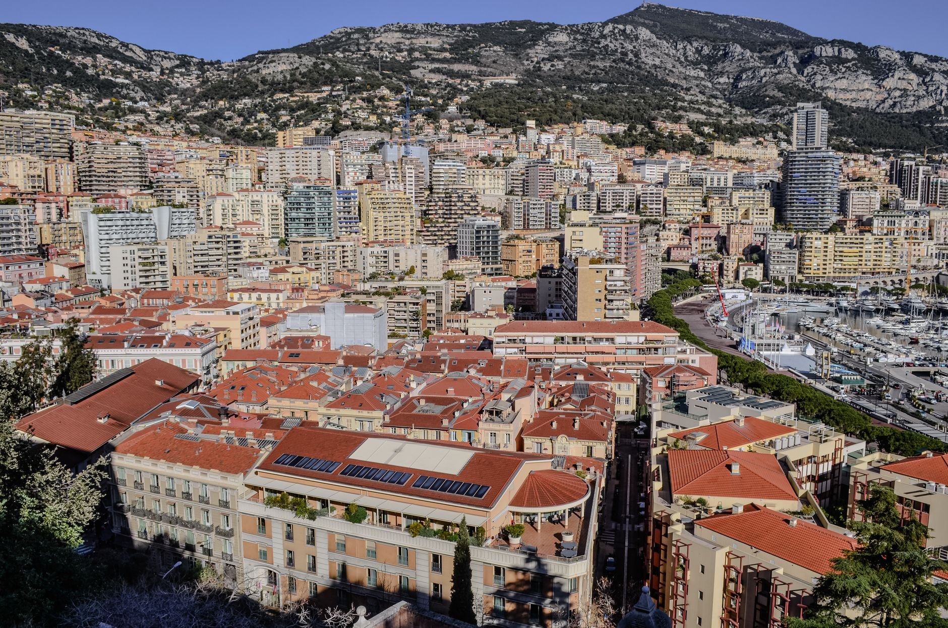 An aerial view of a dense coastal city built onto hillsides above the sea.
