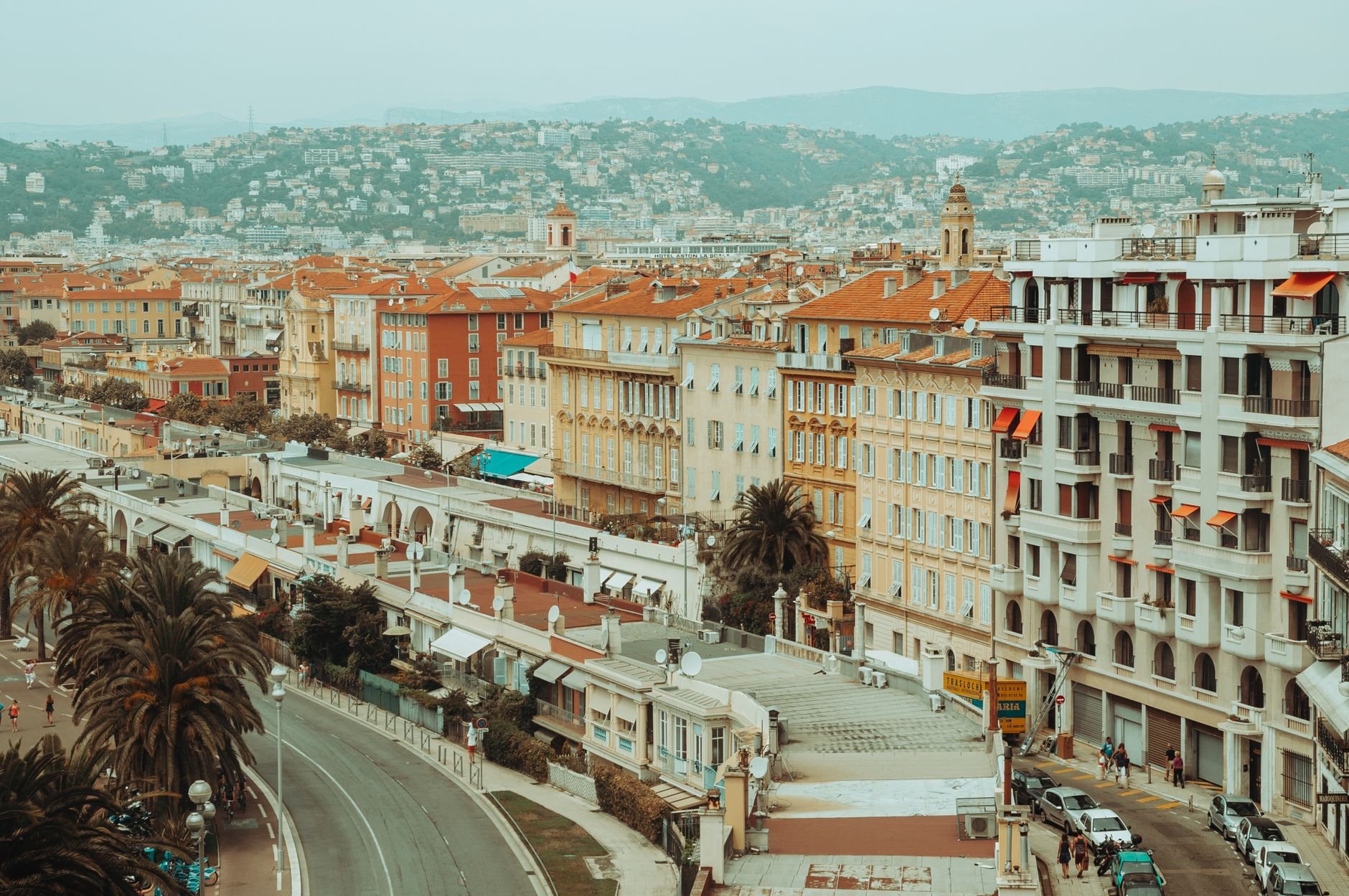 Aerial view of dense buildings along a hillside coastline in southern France.