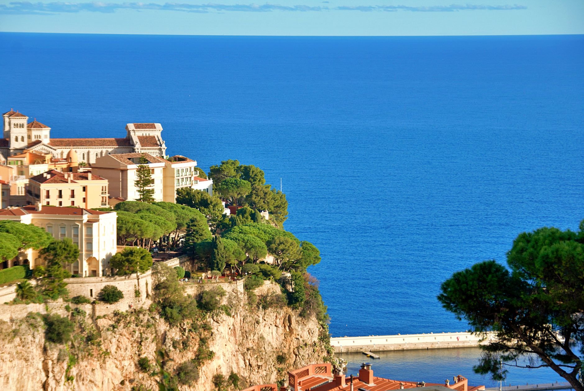 An aerial view of a small coastal city crowded onto a narrow strip of land above the sea.