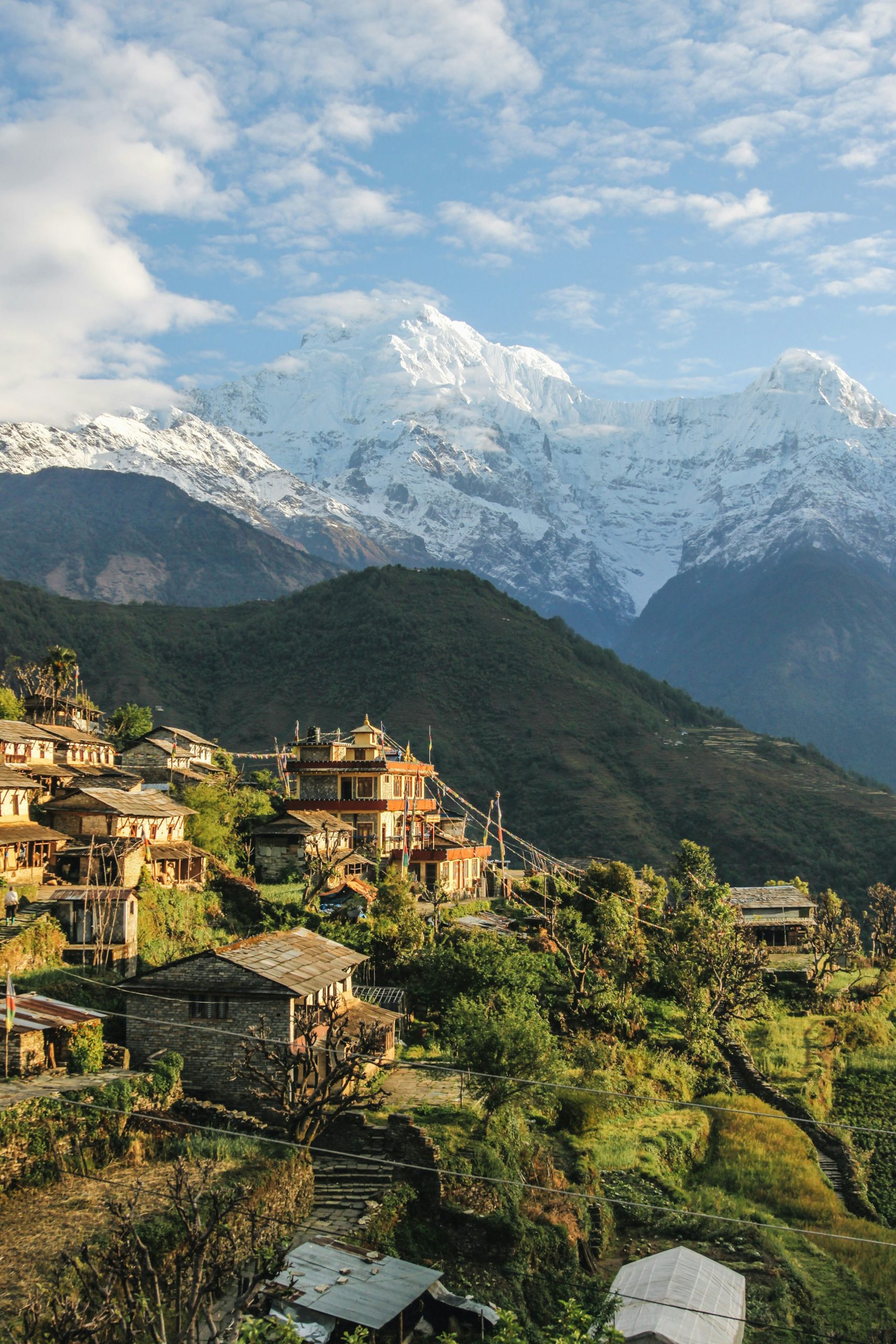 Picture of village with houses in the front and mountains in the background in Narchyang, Nepal.