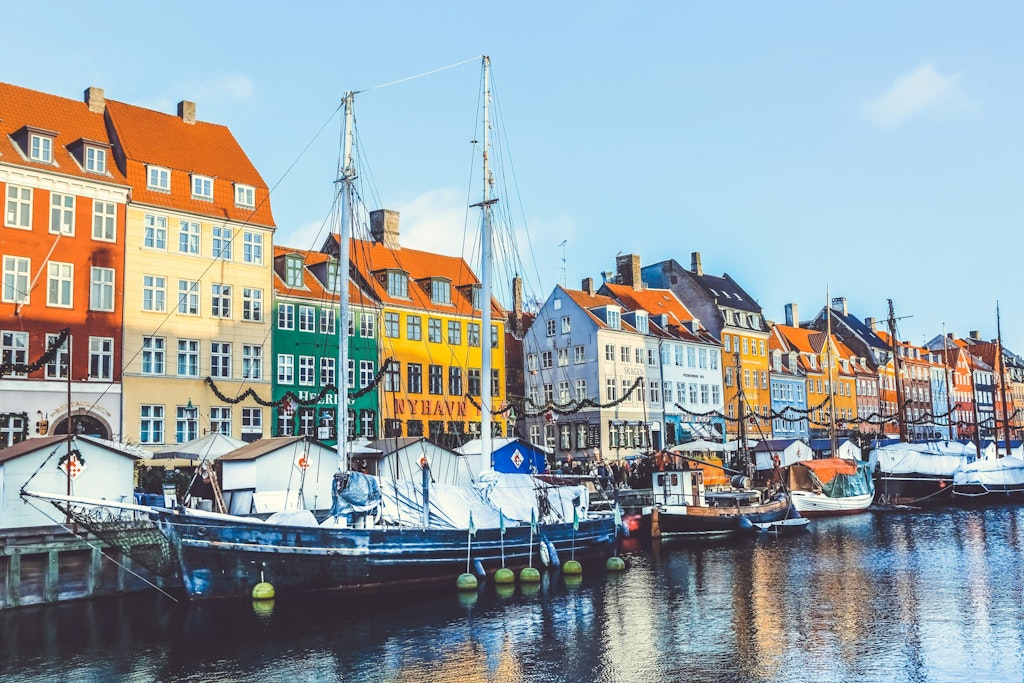 Nyhavn Canal is Copenhagen’s colorful waterfront on Copenhagen Harbour with boats on the river. #Fun Facts about Copenhagen