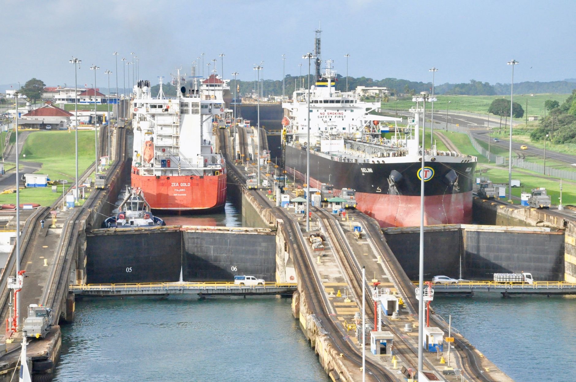Container ships queued to transit a set of canal locks.