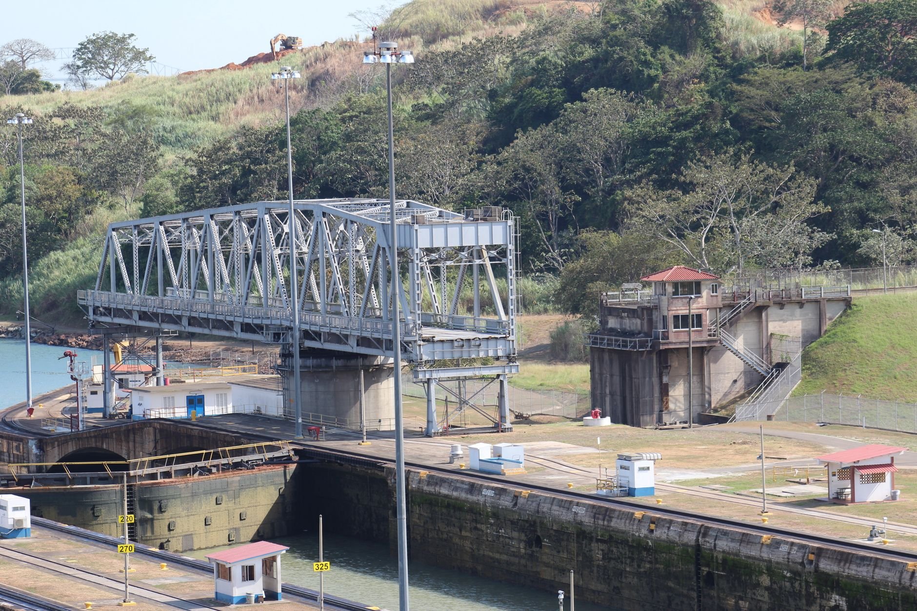 A bridge and canal infrastructure rising above a busy shipping channel.