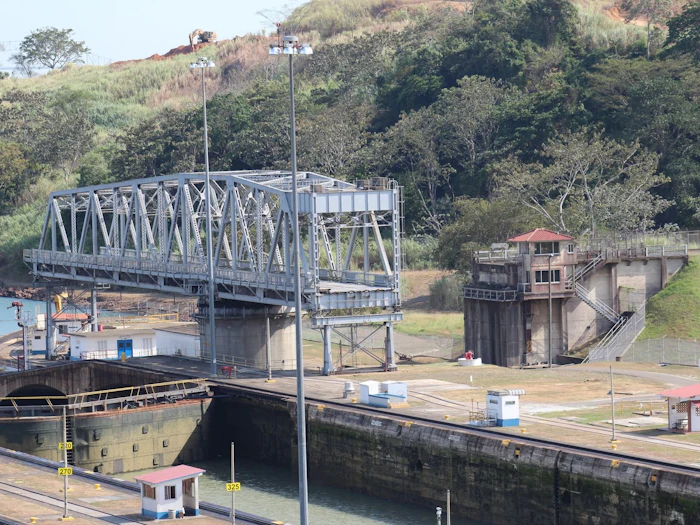 A bridge and canal infrastructure rising above a busy shipping channel.