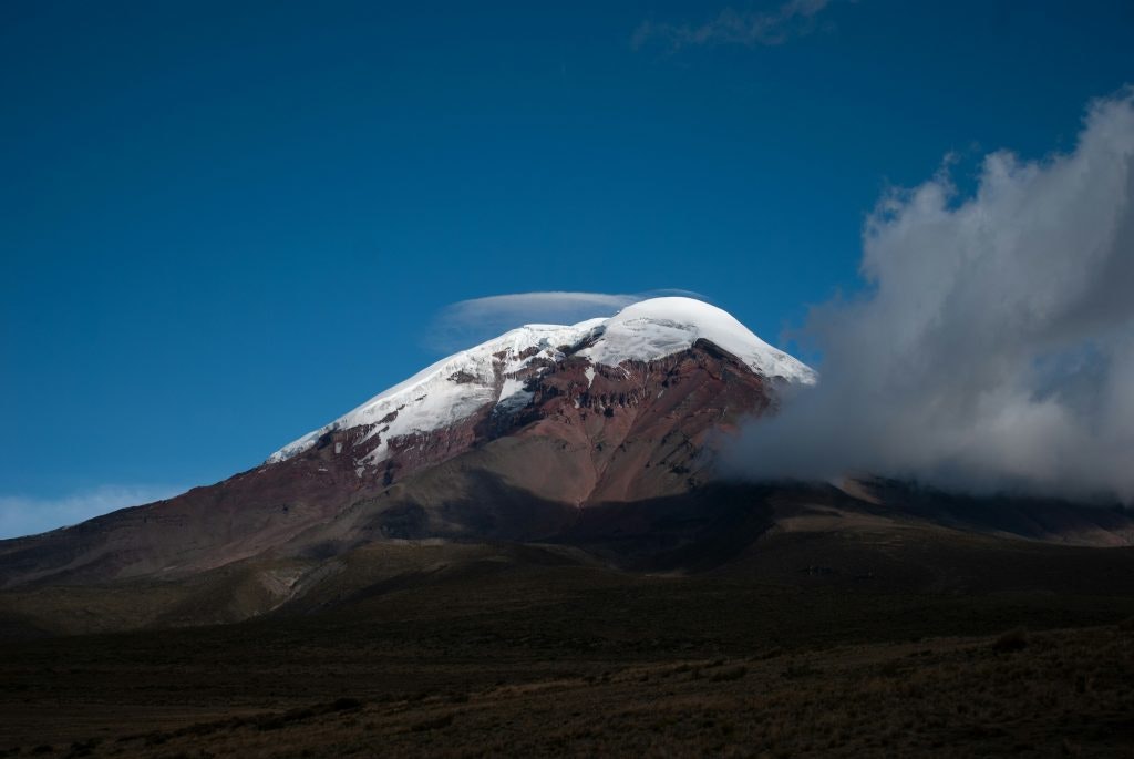 Snow-capped Chimborazo volcano under a clear blue sky in Ecuador.