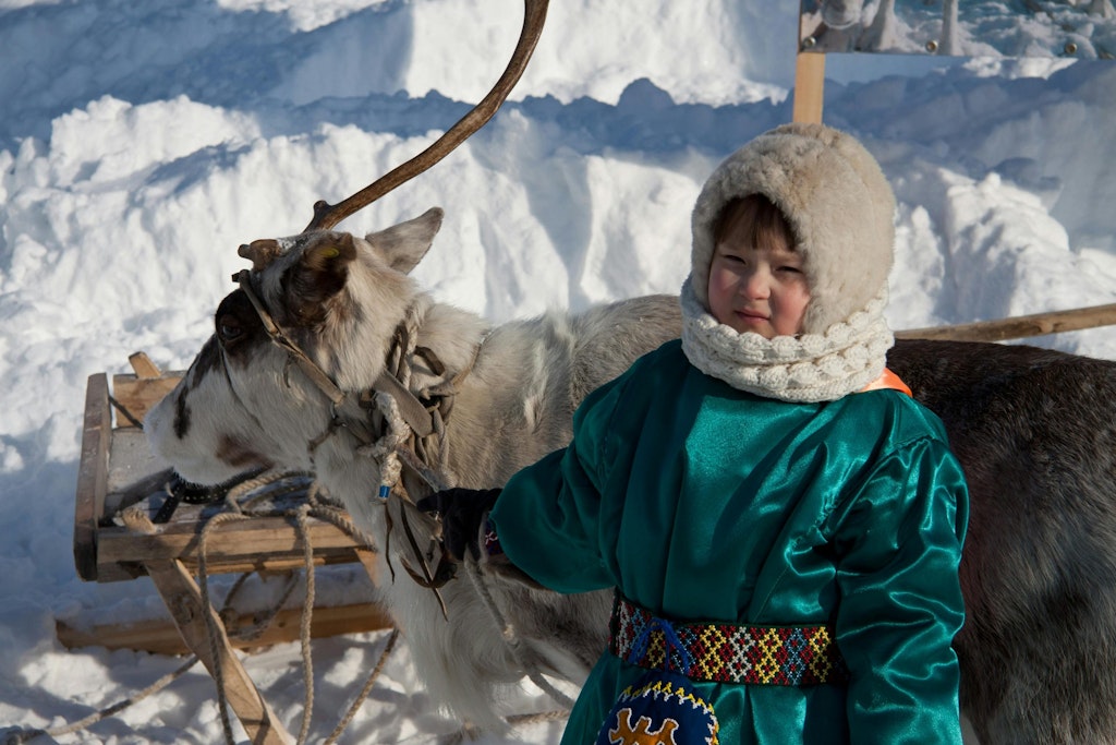 Bilde av Aleksandr Unikovskiy: https://www.pexels.com/nb-no/bilde/sno-jente-vinter-dyr-10535422/ Fun facts about Norway: Photo of a Sami child with a Reindeer out in the snow