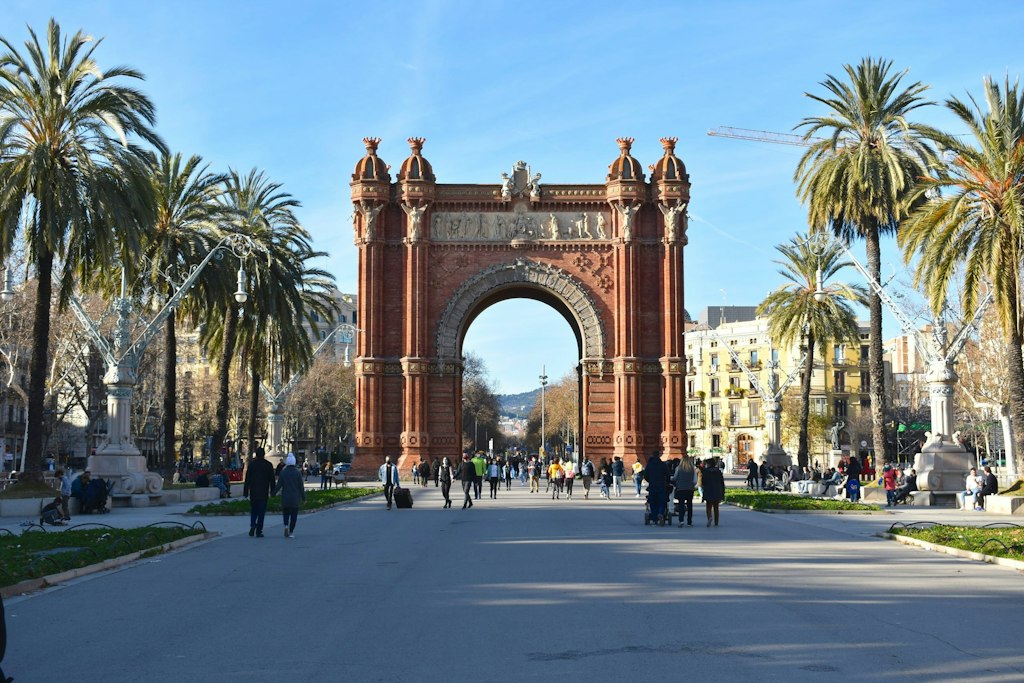 Barcelona's Arc de Triomf can be seen alongside tall palm trees.
