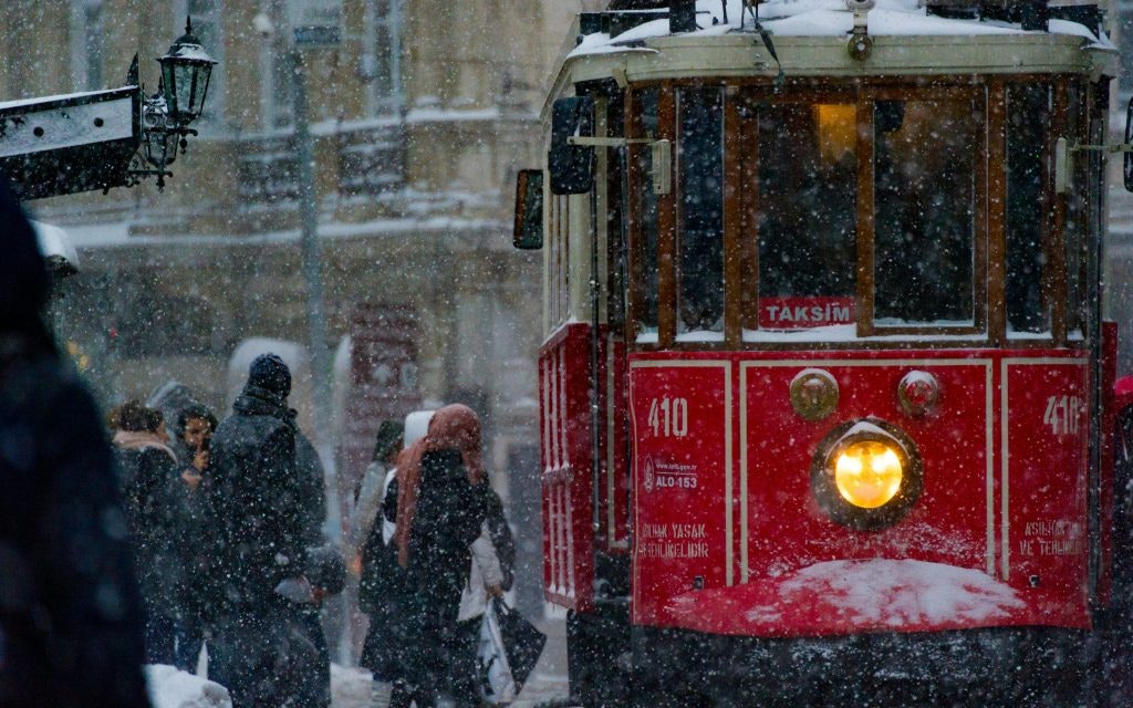 The red Tünel tram picks up passengers in the snow.