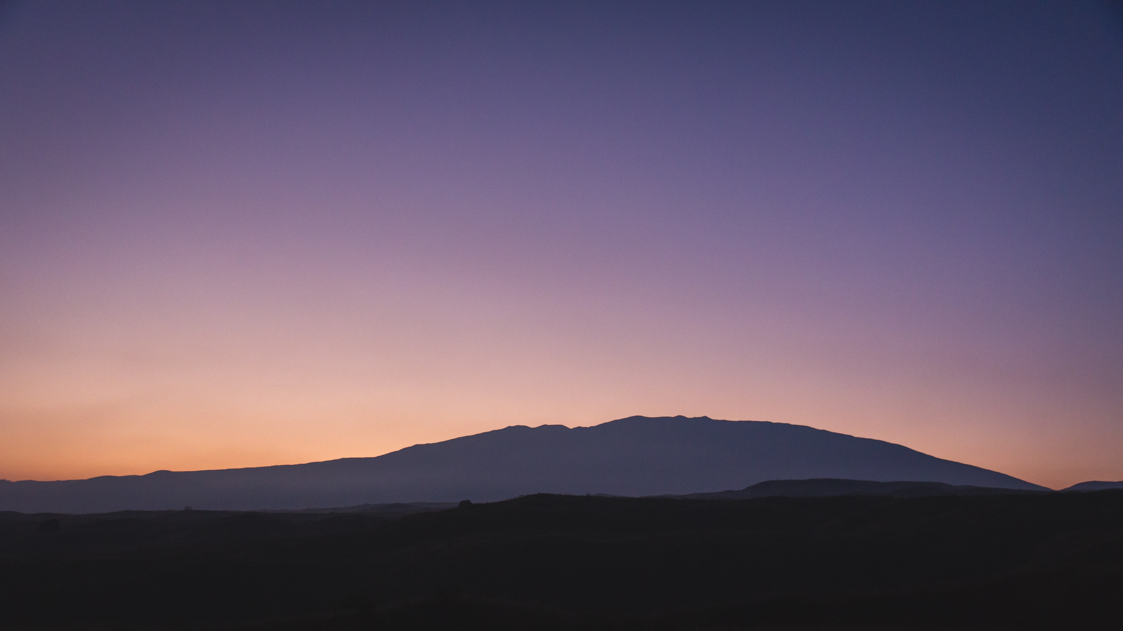 Picture of sunset with a mountain in the background in Hawaii.